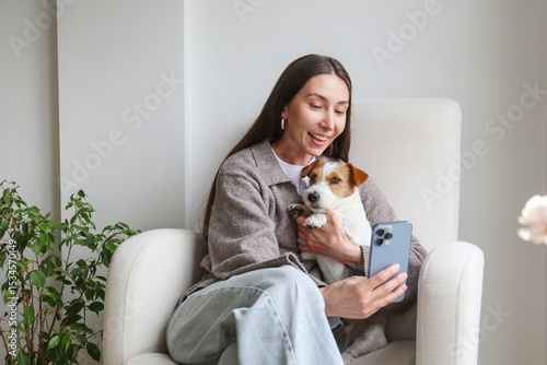 Young woman taking selfies with her dog. Copy space, background.