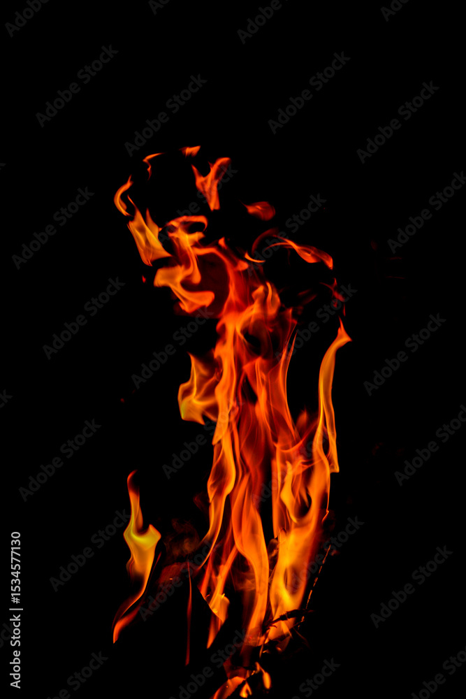Fototapeta premium Close-up Shot of a Bonfire Flame in the Dark – Captivating Fire Texture and Burning Wood with Intense Heat, Perfect for Background
