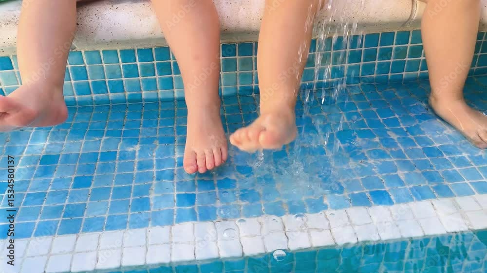 Pies de niños jugando en piscina cristalina