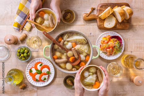 Wallpaper Mural 【ポトフを囲む食卓風景】二人でキャベツの丸ごとポトフ。冬キャベツを丸ごと洋風だしでコトコト煮込みました。 | 【Dinner Table with Whole Cabbage Pot-au-feu】Two people sharing a whole cabbage pot-au-feu at a cozy dinner table. Torontodigital.ca