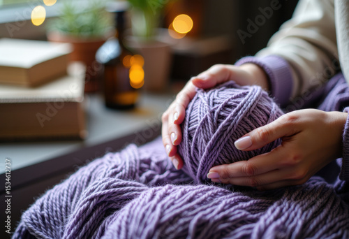 Person knitting with purple yarn, creating a cozy and handmade textile piece photo