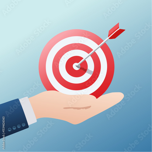 Goal or target, focus and concentration to achieve success, purpose or objective, aiming at target bullseye, accuracy, challenge and aspiration, businessman hand hold target with arrow hit bullsey