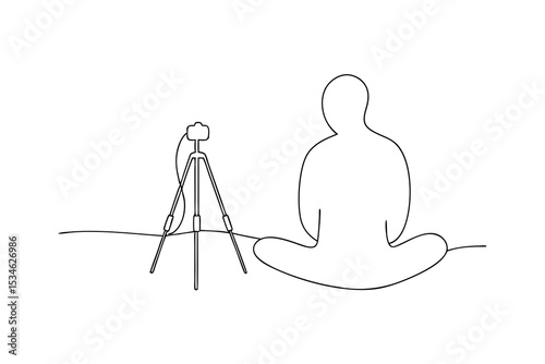 Person sitting cross legged with camera on tripod