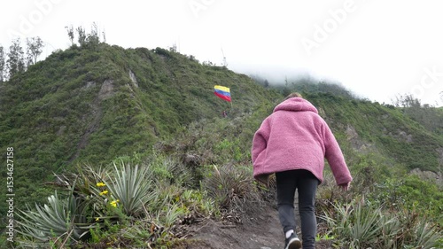 Female traveler walking toward waving Ecuadorian national flag against backdrop of misty Central Sierra mountain landscape, embodying adventurous spirit of exploration and discovery