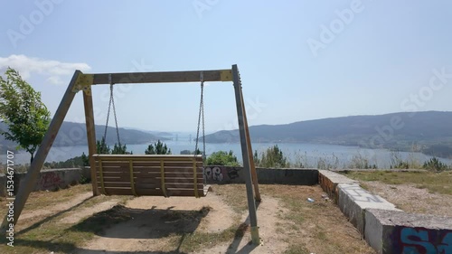 Wooden swing set at mirador outeiro grande offers breathtaking views of vigo, its estuary, and rande bridge photo