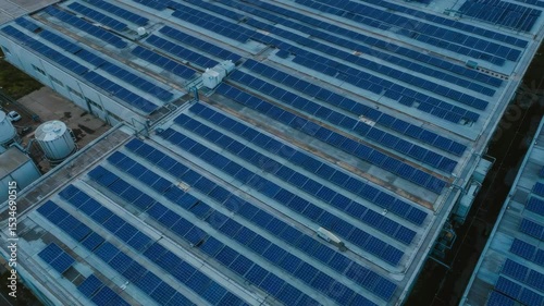 Aerial View of Industrial Rooftops with Solar Panels and Blue Sky