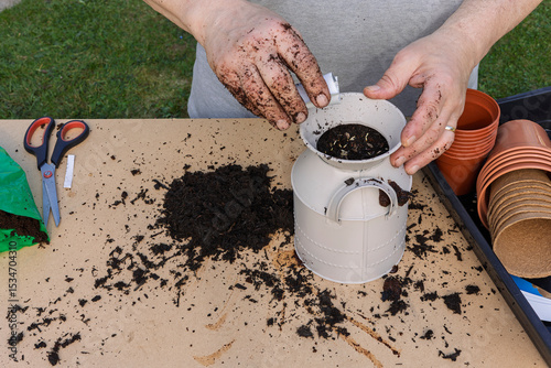 Man Sowing Flower Seeds into a Planter on a garden Potting Bench
