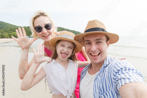 Happy caucasian family taking a selfie picture on smartphone while travel on the beach.