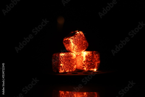 Glowing coals with glitch style lighting, enriched by noise, effect and grain details, create a mystical atmosphere in the dark. A vivid sense of heat and depth surrounds the image