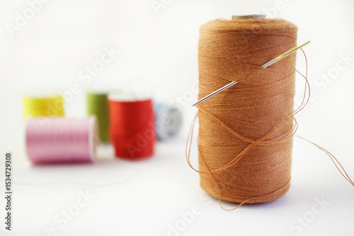 needle and thread with more cotton reels behind
