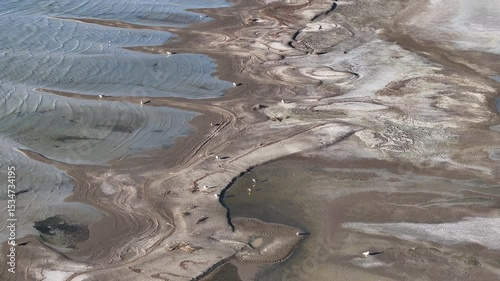 Aerial Great Salt Lake mud shore environment overhead 1. Largest saltwater lake in the Western Hemisphere. Solar evaporation ponds produce salt, potassium, magnesium. Recreation and industry.