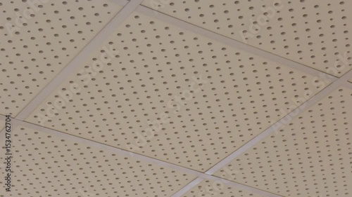 Perforated acoustic panel on the ceiling. The panels are used in concert halls and recording studios, they effectively absorb sound vibrations, making the sound in the room cleaner and more pleasant 