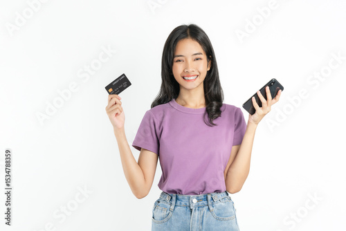 Happy young Asian woman holding smartphone with credit card on white background.