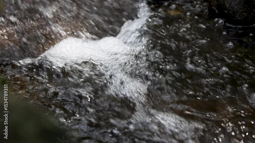A view of a river with clear water and stones in the river basin which is the path of volcanic activity