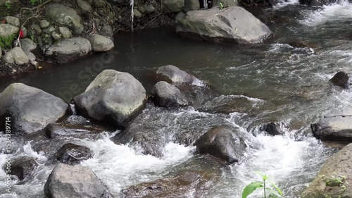 A view of a river with clear water and stones in the river basin which is the path of volcanic activity