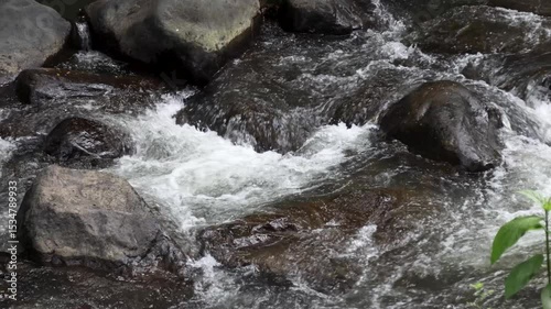 A view of a river with clear water and stones in the river basin which is the path of volcanic activity