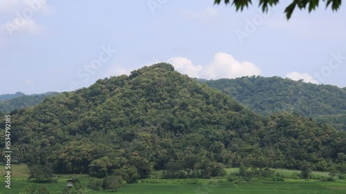 A rural hillside view with expanses of farmland surrounding it