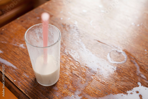 Close up of spilt milk on wooden table top photo
