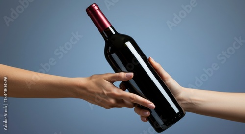 A bottle of wine being passed between two hands