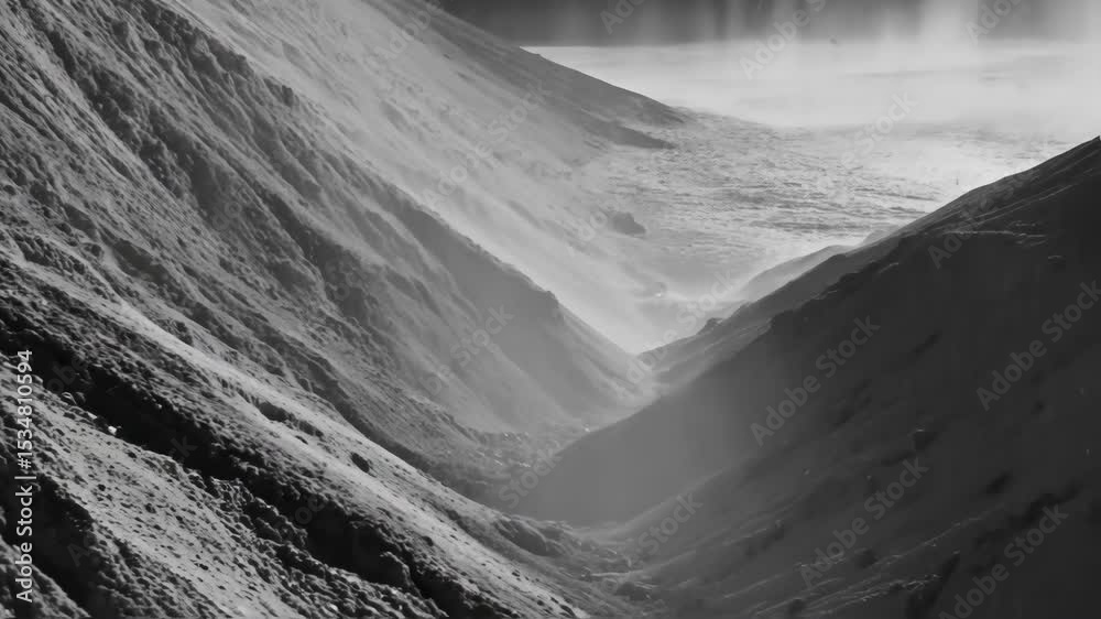 Grayscale landscape of a steep mountain ravine showcasing textured rock formations, foggy weather and a somber, atmospheric mood