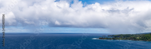 Panoramic view of the ocean and Maui coastline under a cloudy sky.
