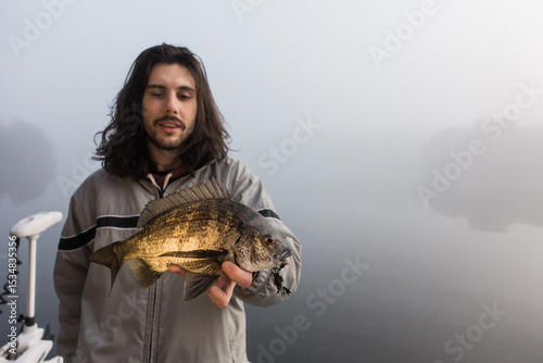 Young Man holding a Bream he Just Caught