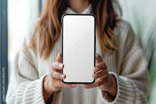 Top View of a Female Holding a Smartphone White Screen Mockup Over a Blurred Background