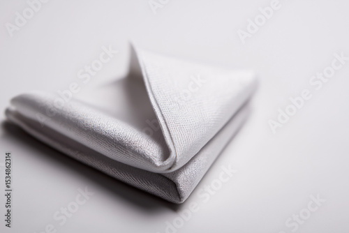 Close-up of folded pocket square corner showing texture on white background, soft shadow, minimalist design great for catalog mockups, formal outfit visuals, or tailoring promotions