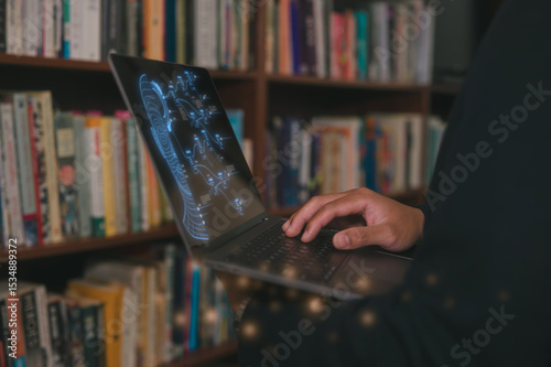 Man typing on computer laptop in library at home, using laptop for work or study. blurred Book filled shelves background