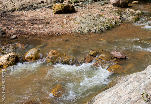 shallow river bottom with a small current in the spring period with various shapes and structures of the riverbed