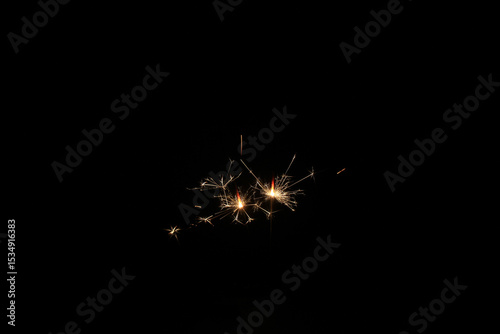 Yellow sparks fly on a black background, layered with grain, noise, and glowing effects to give a gritty, cinematic feel full of motion, contrast, and intense visual energy.