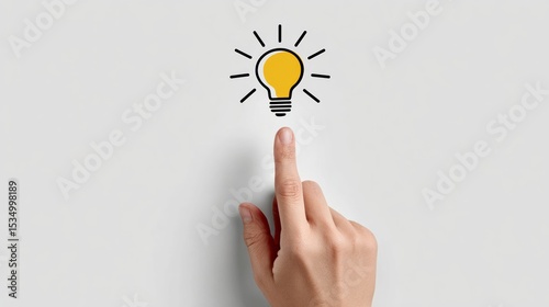 Hand is pressing a button on a white wall with a light bulb on it. The light bulb is lit up and the image conveys the idea of a bright idea or a moment of inspiration