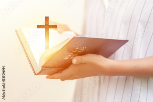 Obraz na plátně Christian woman holding the holy bible book with christian wooden cross
