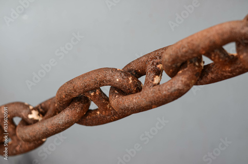 The rusty chain of the anchor on board of platform supply vessel. The chain is attached to a windlass from one and, and to the anchor - from another. Rust does not affect the chain capacity to hold