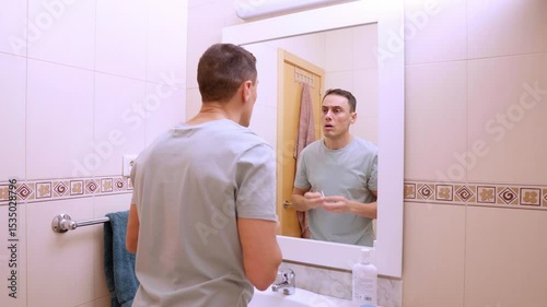 Man removing anti dark circles patches in bathroom