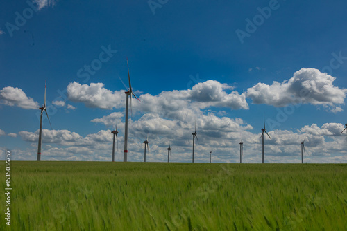 Modern wind turbines spinning over vibrant green fields in rural Germany. A powerful symbol of the Energiewende and Germany’s response to climate change and energy transition. green energy