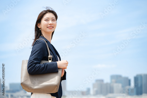 青空バックに立つ女性