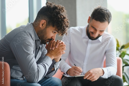 Upset arab man receiving psychological support from therapist