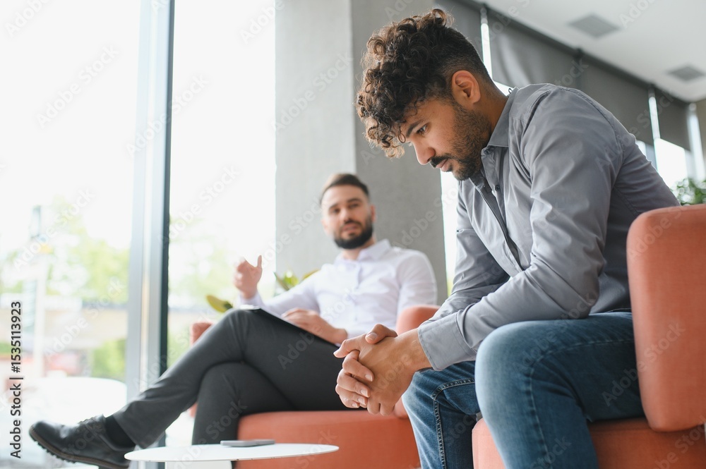 Fototapeta premium Upset arab man suffering from ptsd talking with psychologist