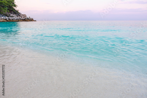 Fototapeta Naklejka Na Ścianę i Meble -  A beautiful beach with a blue ocean and a white rock