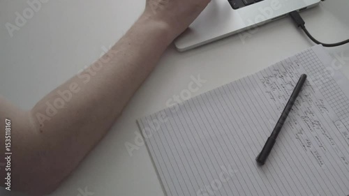 Focused Work – Hand Writing Notes While Working on Laptop