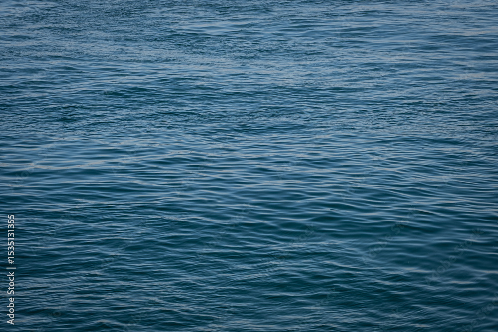 Naklejka premium blue water, sea surface background. small waves in the sea.