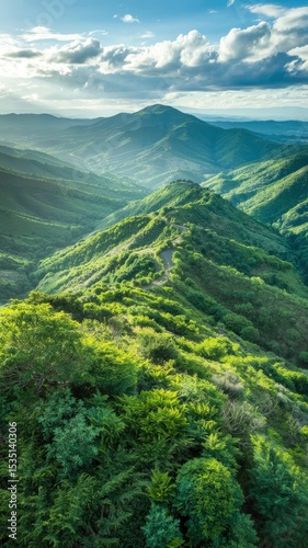 Lush Green Hills Under a Blue Sky with Scenic Mountain Peaks