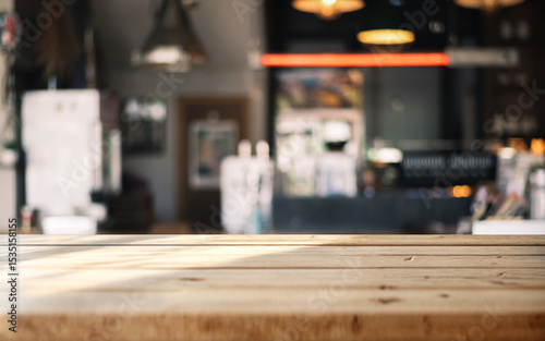 Wooden table with blurred background of cozy café interior and warm lighting.
