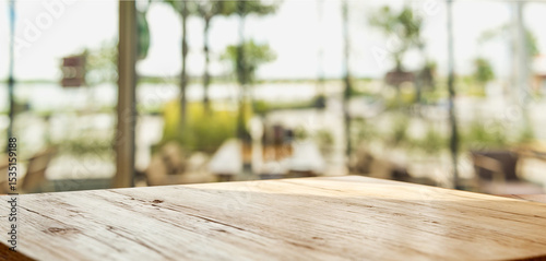 Foreground wooden table with out-of-focus restaurant terrace view.