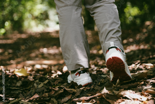 Hiking action on mountain grass trail path. Close up of female hiker shoe. adventurous lifestyle of hiker and backpack to travel and trek mountain, enjoy every walk and hike part of thrilling journey