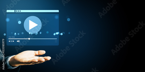 Business hand showing floating video player interface icon on dark blue background with bokeh light, symbolizing streaming service concept.