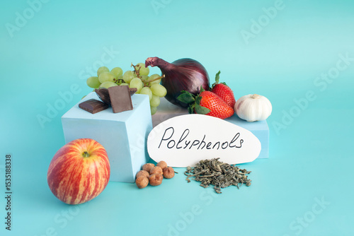 Products containing useful polyphenols in their composition. Grapes, onions, garlic, chocolate and other products in close-up on a light background and the inscription on paper 