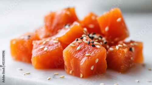 macro shot of diced raw salmon for poke bowl, glistening texture, light soy marinade, sesame seeds, soft focus, vibrant orange color, clean white surface, natural light