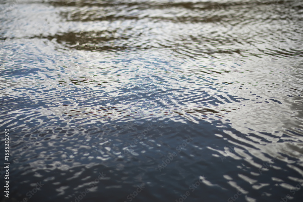 Tranquil Water Surface with Gentle Ripples Reflecting Cloudy Sky in Nature Tranquil Water Surface with Gentle Ripples Reflecting Cloudy Sky in Nature